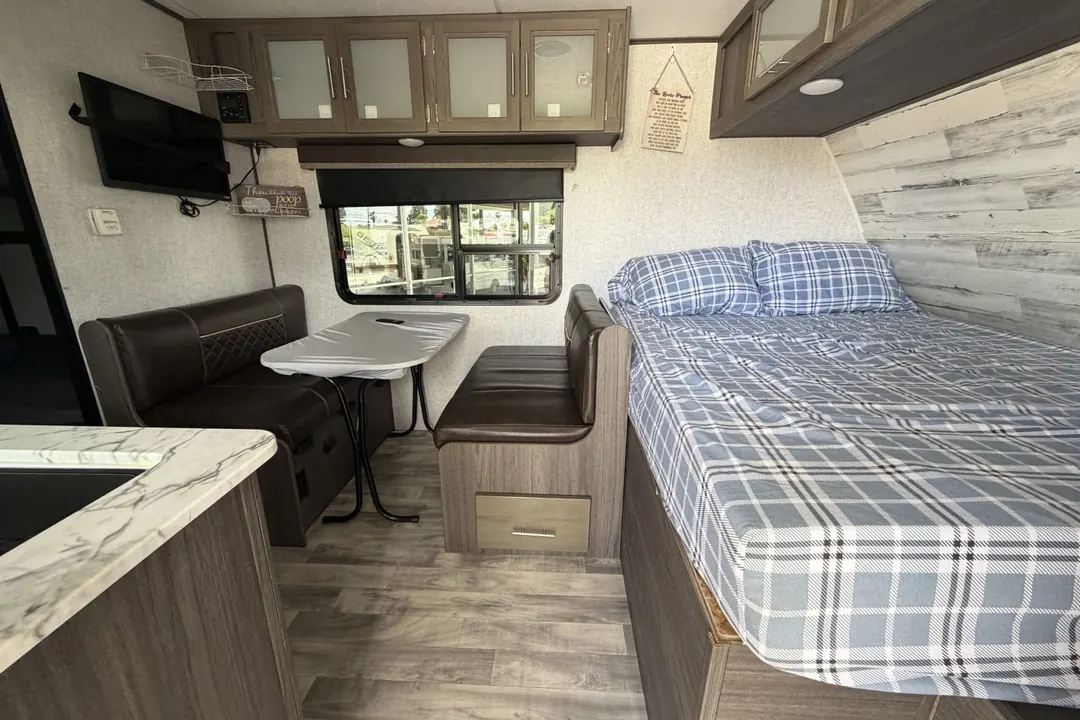The bed and dinette inside a 2021 Dutchmen Kodiak Cub travel trailer