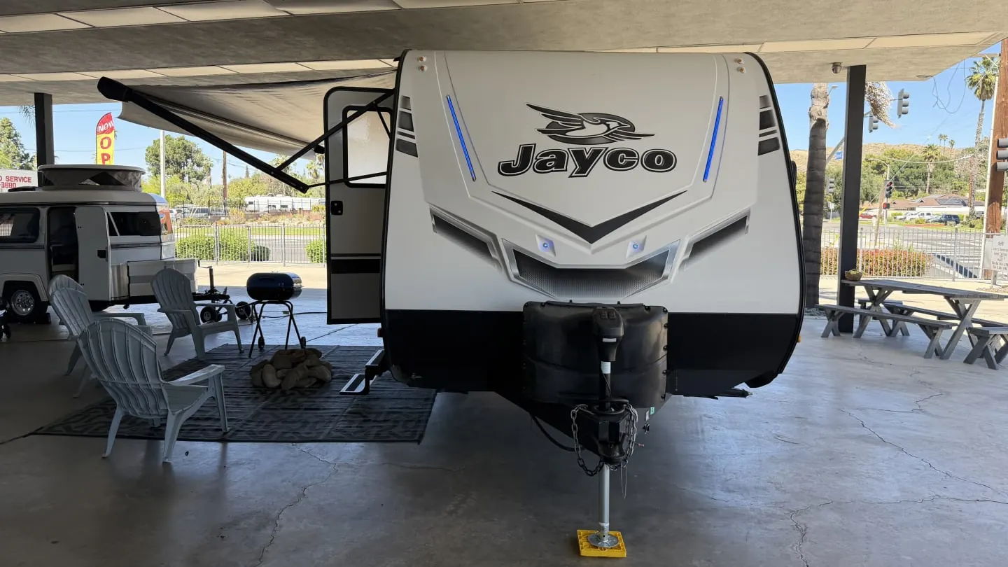 2021 Jayco Jay Feather travel trailer parked under a canopy with chairs set out