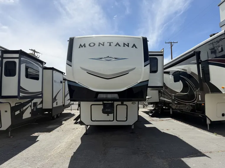 2021 Keystone Montana 3120RL fifth wheel parked between other fifth wheels on a lot