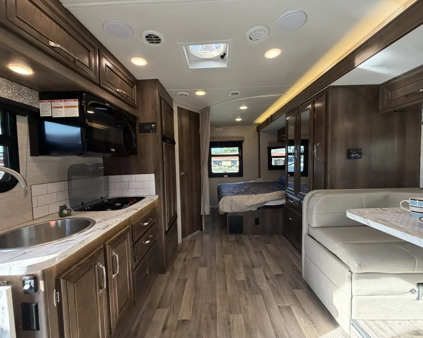 Galley, dinette and rear bed inside a 2021 Jayco Melbourne 24L Class C motorhome