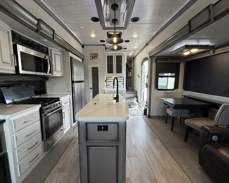 Kitchen island, range and dinette inside a 2021 Keystone Montana 3120RL fifth wheel