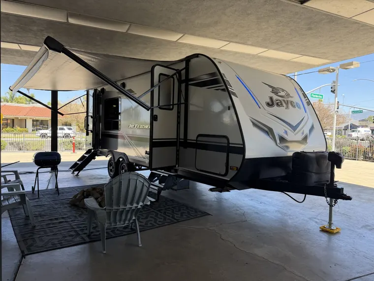 2021 Jayco Jay Feather 22RK travel trailer with its awning out and outdoor seating
