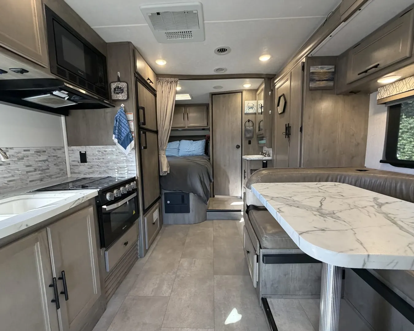 Inside a 2020 Coachmen Prism 2150CB after a turnover: galley, dinette and rear bed